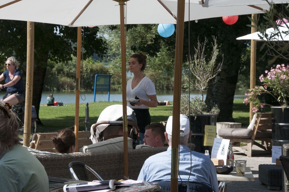 Bediening op het terras met uitzicht op het meer